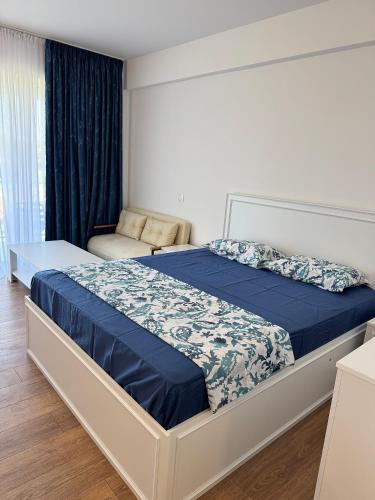 a bedroom with a bed with a blue comforter at Gabriela Blaxy Apartamente in Olimp
