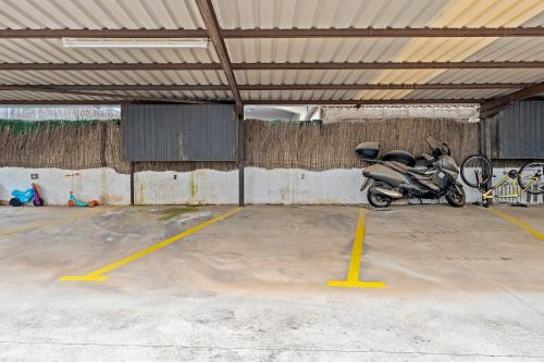 a motorcycle parked in a parking lot at Hauzify I Casa Ribera in Cunit