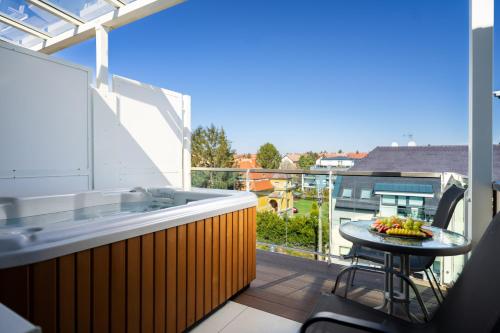 a balcony with a tub and a table on a balcony at Onyx Luxury in Sárvár