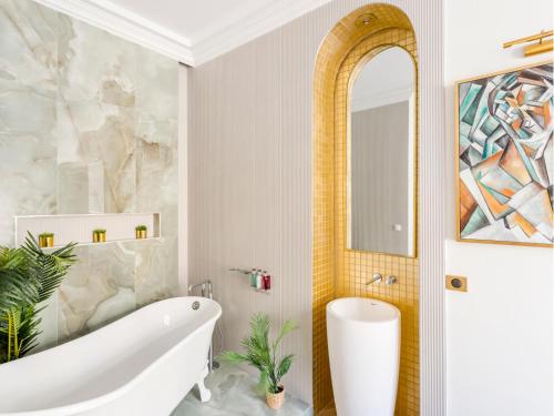 une salle de bain avec une baignoire blanche et un lavabo dans l'établissement Merveil - Luxury Suite - Louvre - Marcel III, à Paris