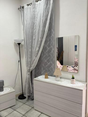una habitación con un tocador con un espejo. en Guest House “Nonna Rossa”, en Nápoles