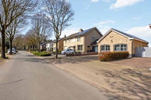 a residential street with houses and a car parked on the road at B&B Oos Heim in Maria-Hoop