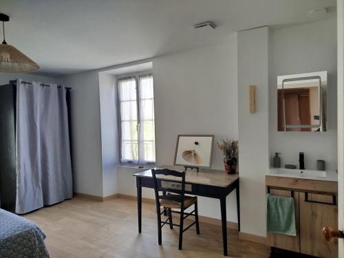 a room with a desk and a table and a sink at Gîte Ô Passage in Damvix