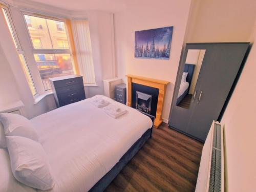 a small bedroom with a bed and a fireplace at Beautiful home near LFC Stadium in Liverpool