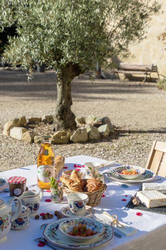 une table avec des assiettes de nourriture et un arbre dans l'établissement La Cour Souveraine - Chambre d'hôtes La Péninsule, à Mosles