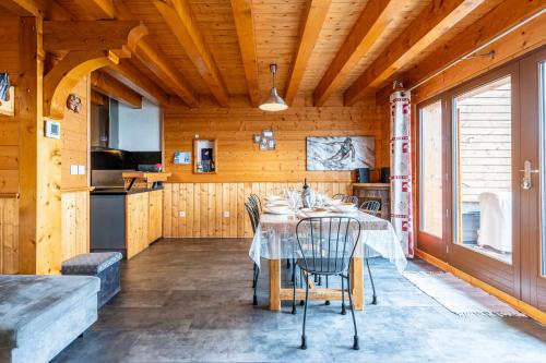 une salle à manger avec une table et une cuisine dans l'établissement Chalet Les Skieurs, à Notre-Dame-du-Pré