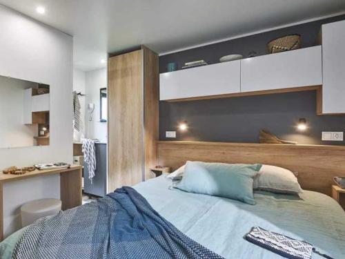 una camera da letto con un letto grande e una scrivania di Camping 4 étoiles - Piscine - eeebgi a La Faute-sur-Mer