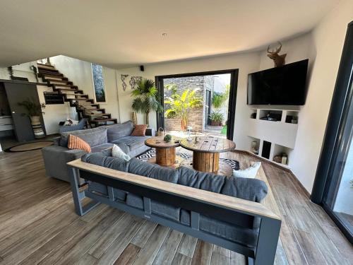 a living room with a couch and a table at VILLA FENG SHUI déco bali St Aygulf 3 chambres in Saint-Aygulf