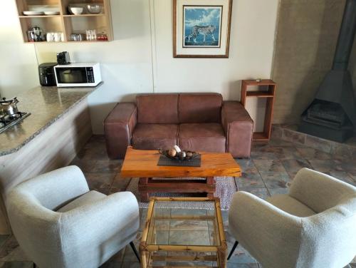 a living room with a couch and two chairs and a table at The Stix in Dullstroom