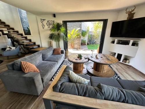 a living room with couches and tables and a television at VILLA FENG SHUI déco bali St Aygulf 3 chambres in Saint-Aygulf