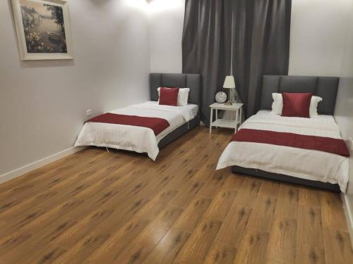 two beds in a room with wooden floors at فلل بندورا in Khamis Mushayt