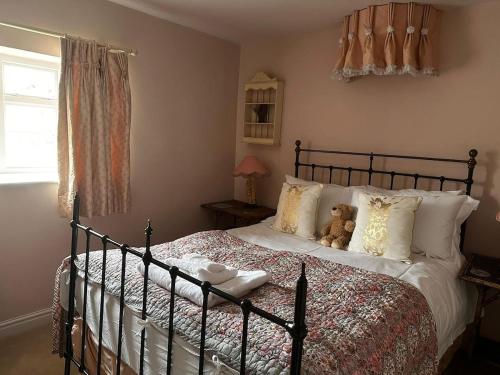 a bedroom with a bed with a teddy bear on it at Stunning 2 bed Flat Near Belvoir Castle in Croxton Kerrial