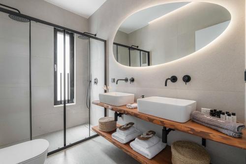 a bathroom with two sinks and a mirror at Nimbus Villas in Kalamitsi