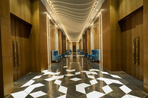 a hallway with blue chairs and a checkered floor at Palm Springs Resort in Nashik