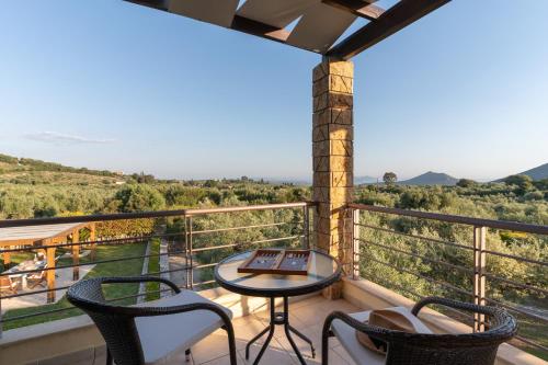 a balcony with chairs and a table and a view at Villa Callisti in Pylos