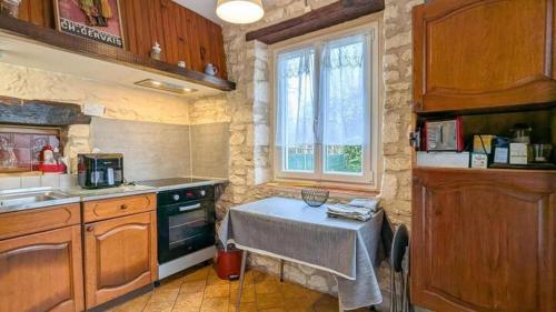 a kitchen with a table and a sink and a window at Gite de charme au cœur de la Brenne in Paulnay