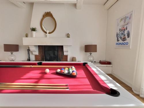 a red pool table with cue balls on it at Domaine De Bonaveau - Privatisation Spa et Piscine in Barcelonne