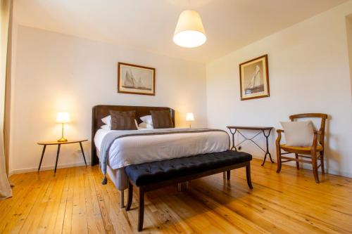 a bedroom with a bed and two chairs in it at Domaine De Bonaveau - Privatisation Spa et Piscine in Barcelonne