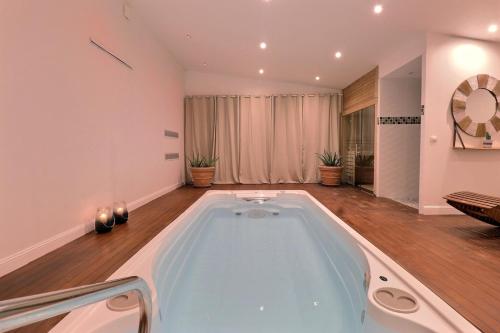 a large bath tub in a living room at Domaine De Bonaveau - Privatisation Spa et Piscine in Barcelonne