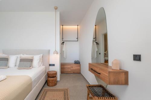 a bedroom with a bed and a dresser and a mirror at Nimbus Villas in Kalamitsi