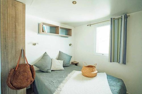 Un dormitorio con una cama con una cesta encima. en Camping 3 étoiles - Parc aquatique - eeibbf, en Fouesnant