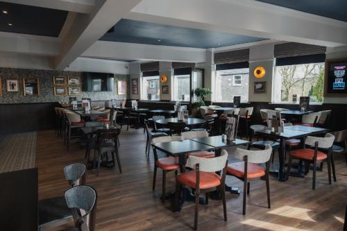 a restaurant with tables and chairs in a room at Black Dog Inn in Bolton