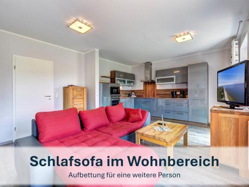 a living room with a red couch and a tv at Peenemünde, Seglerhafen_SB_Trimaran 4 WE in Peenemünde