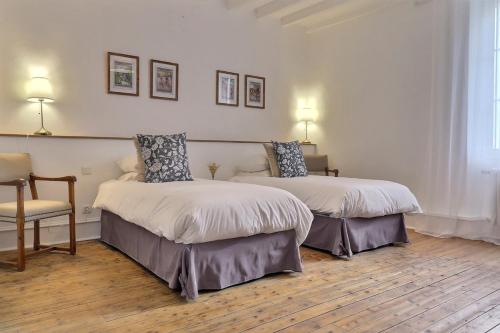 a hotel room with two beds and a chair at Domaine De Bonaveau - Privatisation Spa et Piscine in Barcelonne