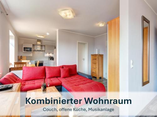a living room with a red couch and a kitchen at Peenemünde, Seglerhafen_SB_Trimaran 4 WE in Peenemünde
