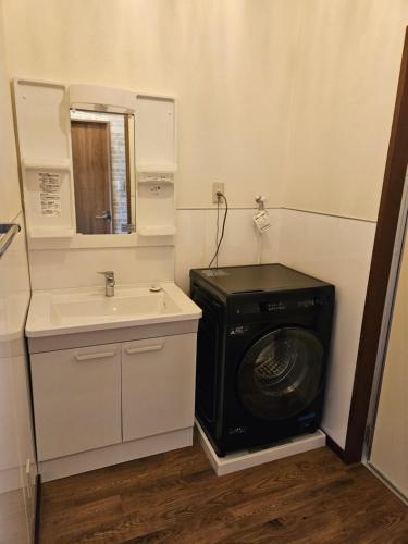 a bathroom with a washing machine and a sink at Cozy Barn Ishigaki in Ishigaki Island