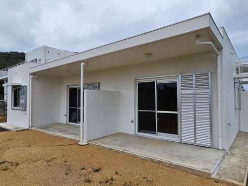 a white house with a garage at Cozy Barn Ishigaki in Ishigaki Island