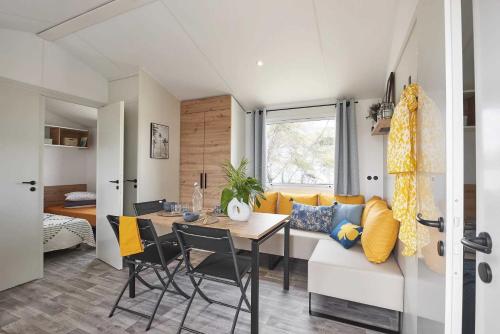 - une salle à manger et un salon avec une table et un canapé dans l'établissement Camping 4 étoiles - Parc aquatique - eeic0f, à Biscarrosse