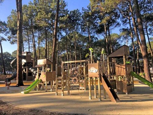 un parc avec une aire de jeux avec des toboggans et une structure de jeux dans l'établissement Camping 4 étoiles - Parc aquatique - eeic0f, à Biscarrosse