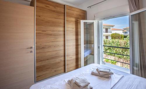 スカラ・フォルカスにあるSunkissed beachfront holiday homeのベッドと大きな窓のある寝室