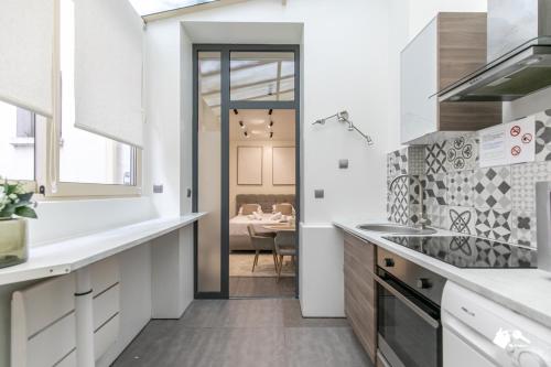 une cuisine avec des comptoirs blancs et une salle à manger dans l'établissement MBA - Splendide Appartement - Proche Nation, à Paris