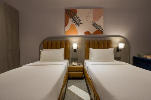 two beds sitting next to each other in a room at Palm Springs Resort in Nashik