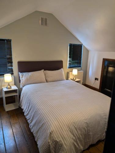 a bedroom with a large bed with two lamps at 3B-10min City Airport Parking No Parties allowed in London