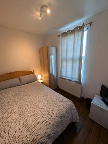 a bedroom with a bed and a window at 3B-10min City Airport Parking No Parties allowed in London