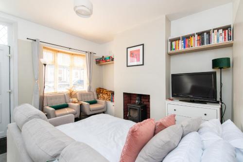a living room with a white couch and a tv at Central 2 BR Cosy House in Rugby