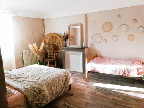 a bedroom with two beds and a mirror on the wall at Maison de caractère 170m2 coeur de village in Saint-Montan