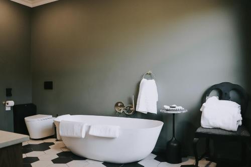 a bathroom with a white tub and a toilet at The Rasmus in Pretoria