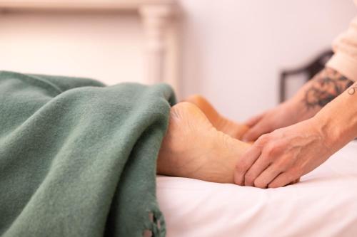 a man laying on a bed with his foot on a pillow at Palacio de los Leones in Lora del Río