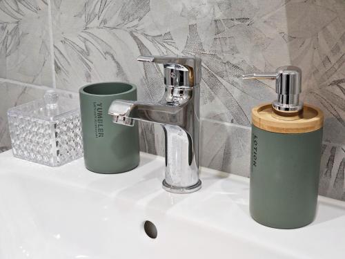 ヴァルナ・シティにあるStudio Jadeの蛇口と2つのカップが付いたバスルームのシンク