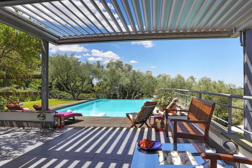 a deck with a pool and chairs and a table at Luxury Villa Lanuvio - Piscina e Hammam by Flatinrome in Lanuvio