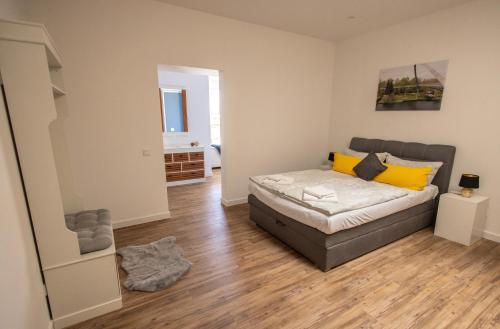 a bedroom with a bed with yellow pillows on it at Havelpension in Rathenow