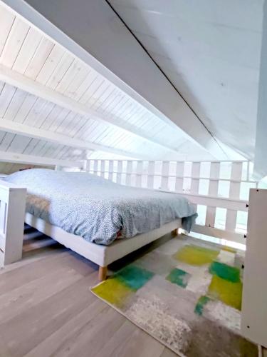 une chambre avec un lit dans un grenier dans l'établissement Chalet cosy, plages à pieds. Morbihan., à Plouhinec