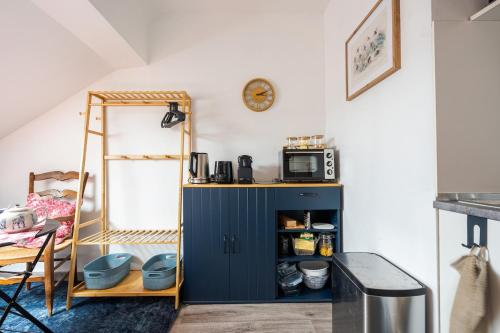 - une cuisine avec une armoire bleue et un four micro-ondes dans l'établissement Chez granny, à Angers