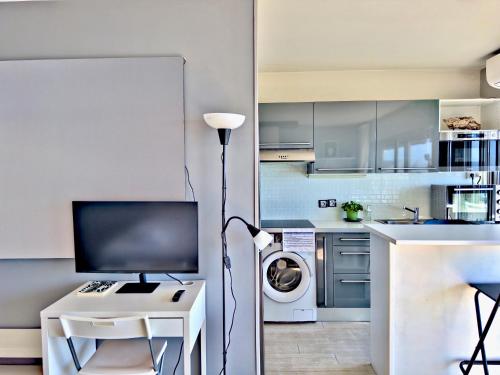 une cuisine avec un bureau avec un ordinateur et une machine à laver dans l'établissement Panoramic Sea View Studio 24h Checkin, à Cagnes-sur-Mer