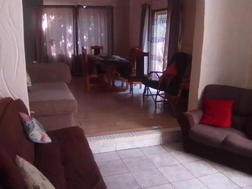 a living room with a couch and chairs and a table at M and M Home from Home in Port Edward