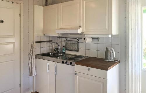 a kitchen with white cabinets and a sink at 1 Bedroom Cozy Home In Färjestaden in Färjestaden